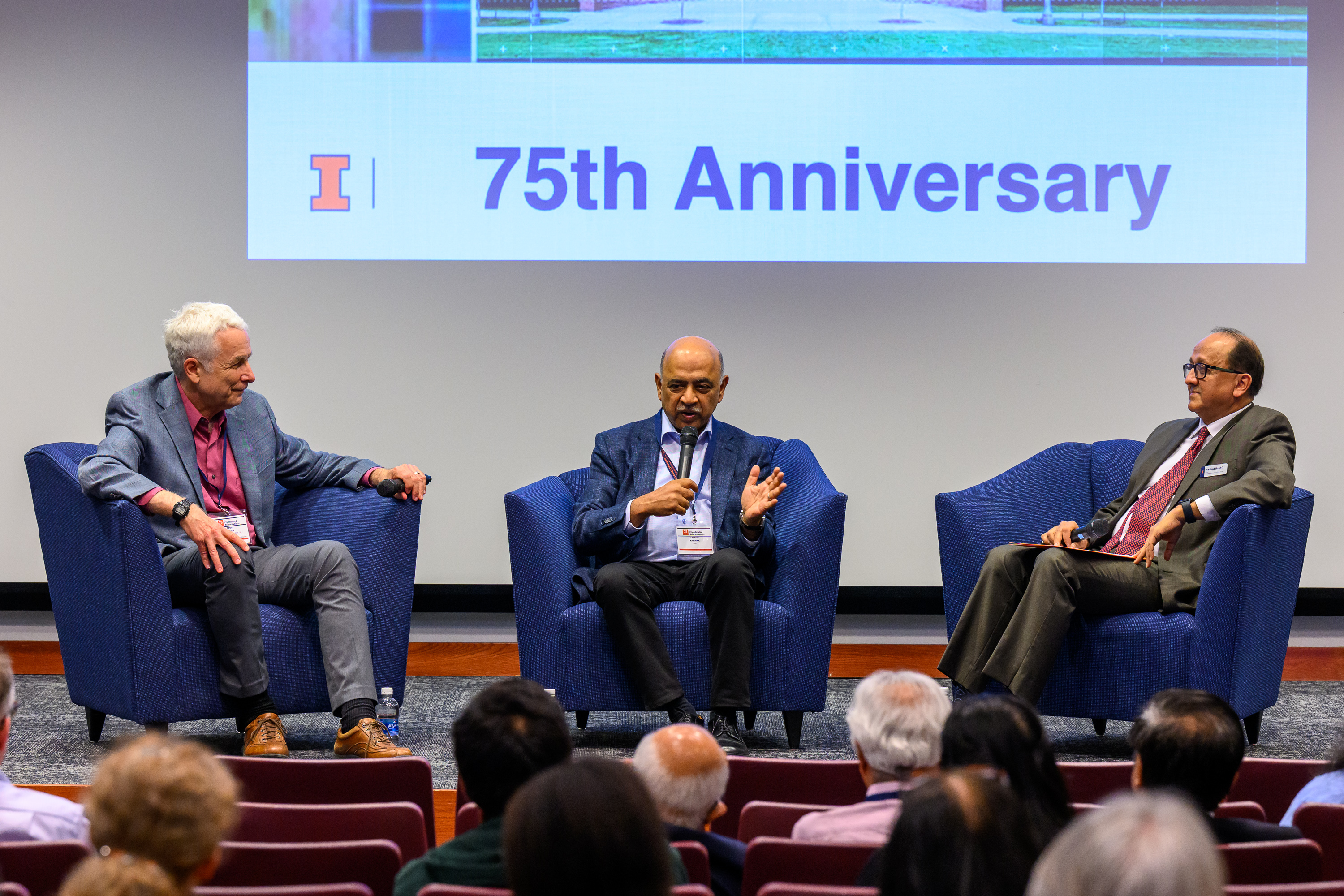 Photo of men sitting in front of auditorium