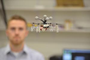 Grad student Mitchell Jones flys a mini drone in CSL's Intelligent Robotics Lab.