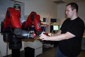 Aerospace engineering student Andy Borum works with Baxter, a robot designed for small business manufacturing.