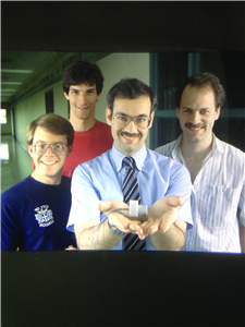 Joseph Lyding (center) with graduate students (from left to right) Steve Skala, Jerome Hubacek and Gordon Gammie, presenting the scaled-down version of his scanning tunneling microscope.