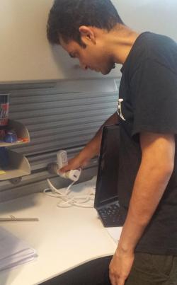 ADSC researcher Varun Krishna installs power meters at every workspace in the ADSC offices to monitor their total energy consumption.