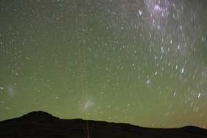An image of the night sky with four laser beams emitted by the University of Illinois Sodium LIDAR at the Andes Lidar Observatory in Chile. The long exposure records the laser beam as it&rsquo;s directed to the zenith and three angles off the zenith to measure Doppler winds in the 80-105 km altitude region above the observatory, using a laser resonance method with atmospheric sodium.