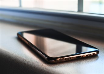 A cell phone sitting on a desk.